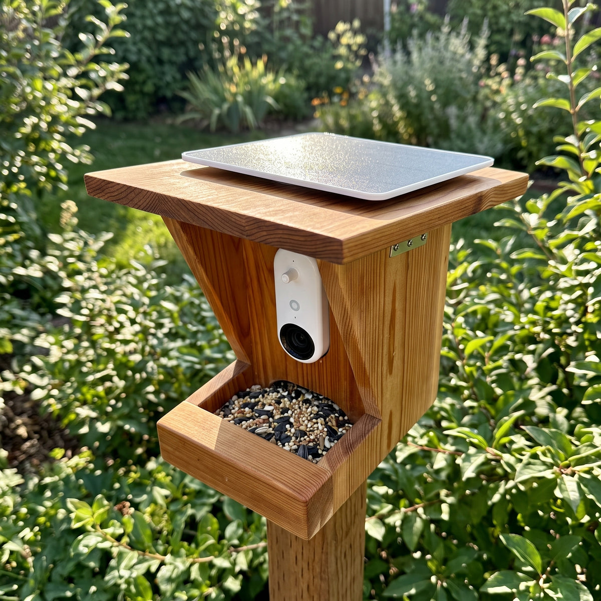 Top angle close-up of weather-sealed roof solar panel and stainless steel side hinge on tung-oil finished cedar bird feeder