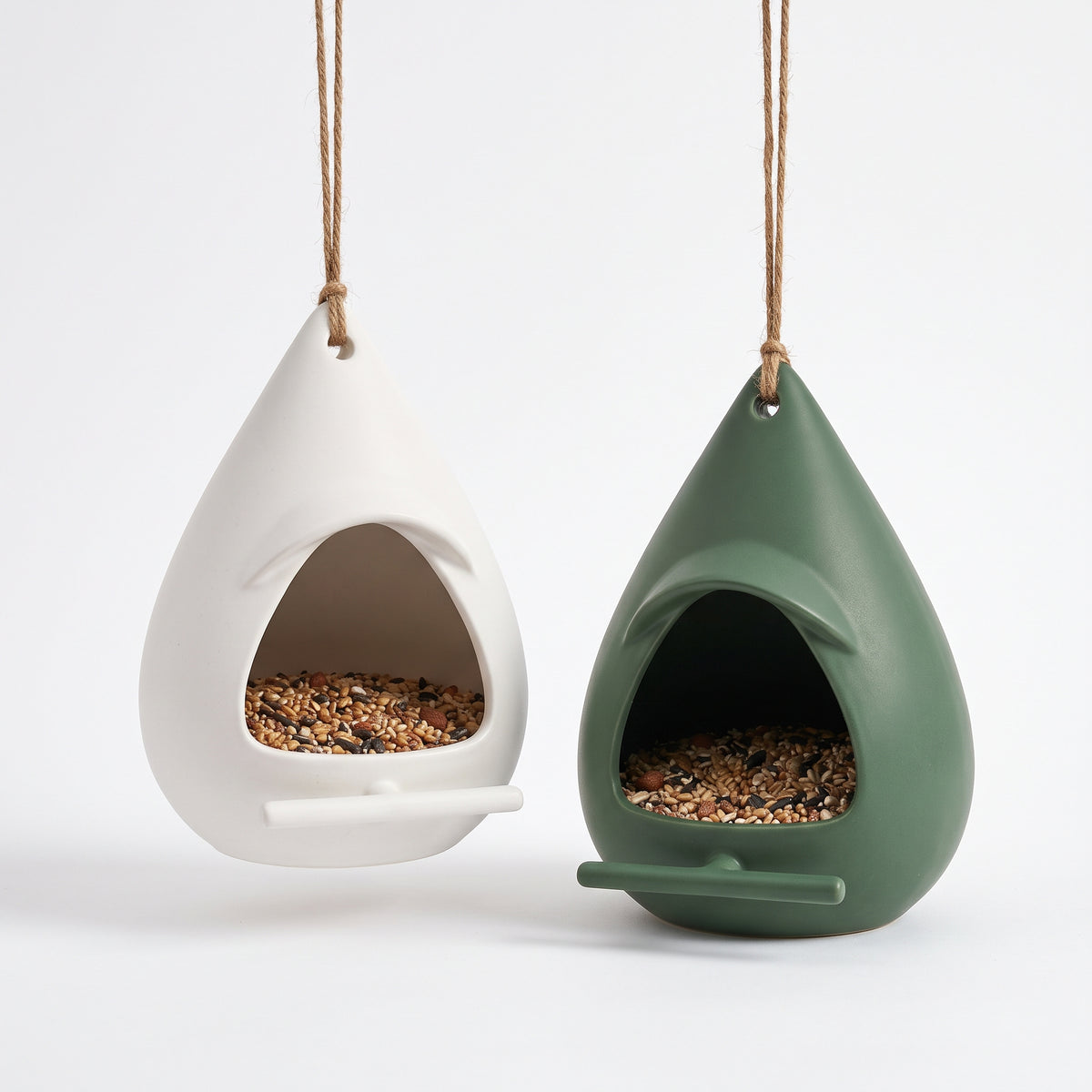 Nordic teardrop hanging bird feeders in Matte White and Garden Green with overhanging rain hoods, front perching bars, and natural jute cords