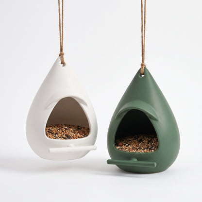 Nordic teardrop hanging bird feeders in Matte White and Garden Green with overhanging rain hoods, front perching bars, and natural jute cords